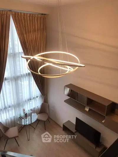 Modern living room with high ceiling and stylish lighting fixture