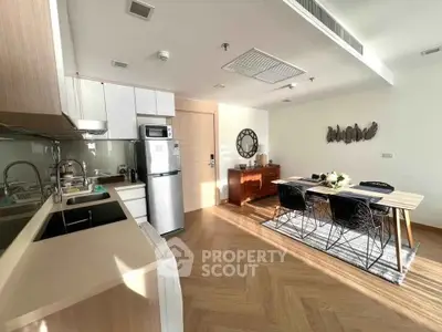 Modern open-layout kitchen and dining area with sleek appliances and stylish decor.
