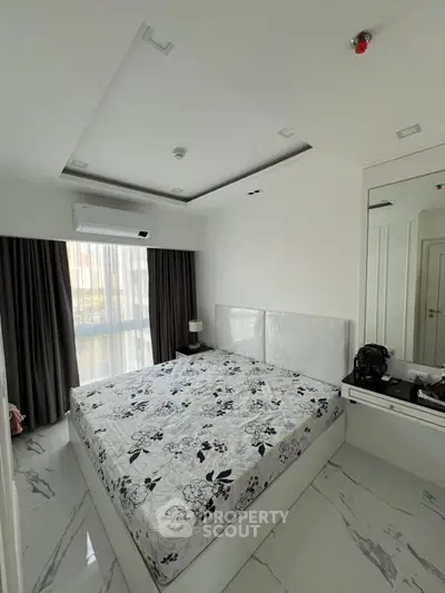 Modern bedroom with sleek design and large window for natural light.
