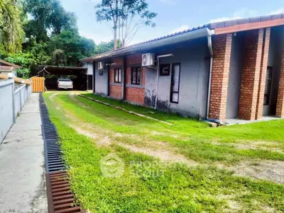 Charming single-story brick house with lush green lawn and carport, perfect for family living.