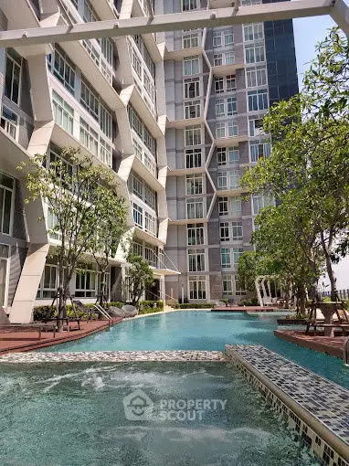 Luxurious modern apartment building with stunning pool and lush greenery