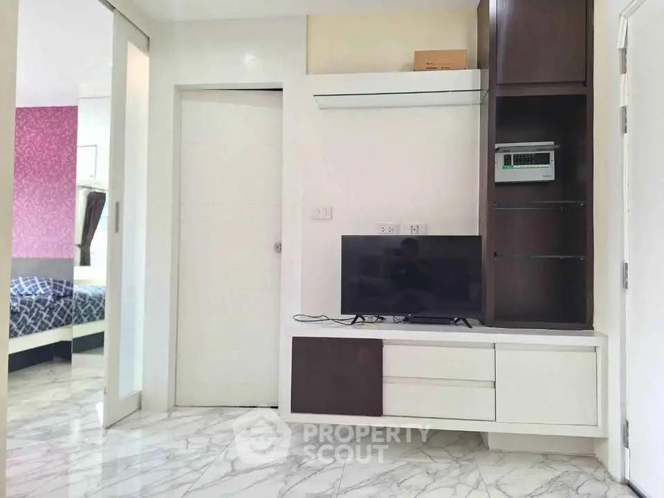 Modern living room with sleek TV unit and marble flooring in stylish apartment.