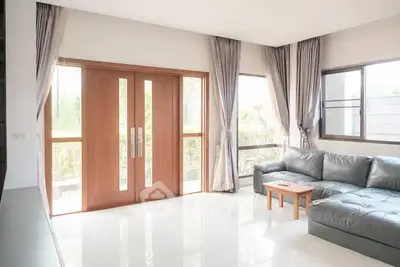 Spacious living room with modern leather sofa and large windows