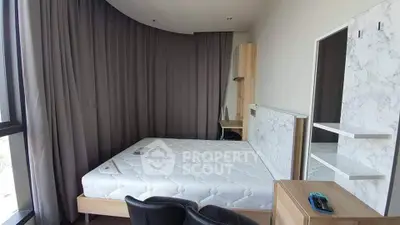 Modern bedroom with stylish decor and large window, featuring a comfortable bed and elegant furnishings.