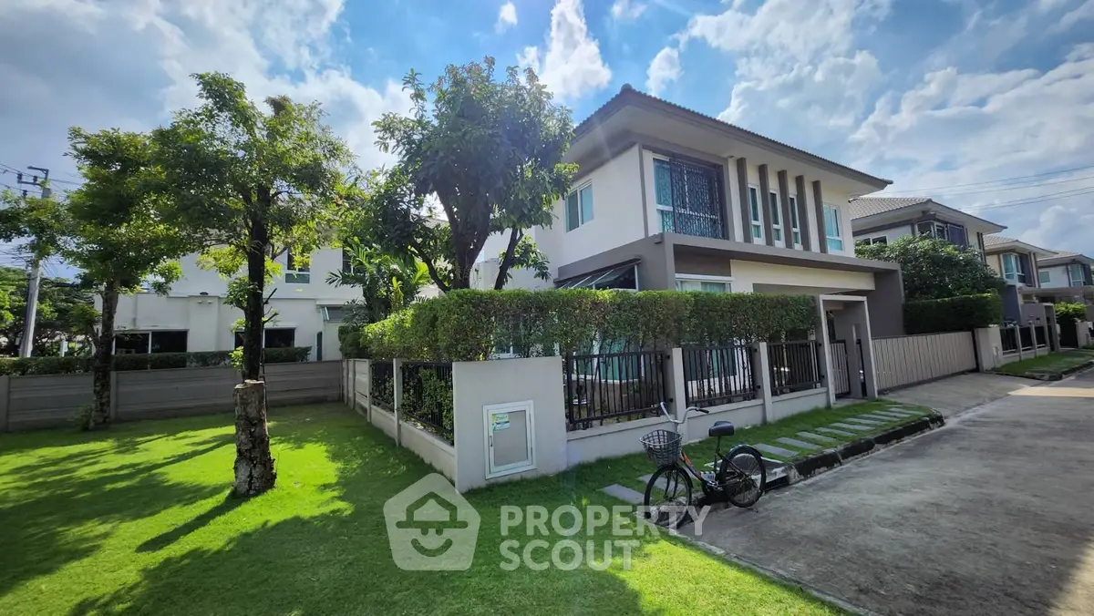 Modern two-story house with lush garden and bicycle in serene neighborhood.
