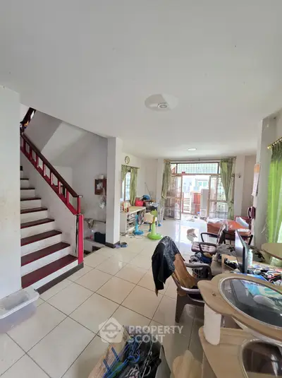 Spacious living room with staircase and natural light, ideal for family gatherings.