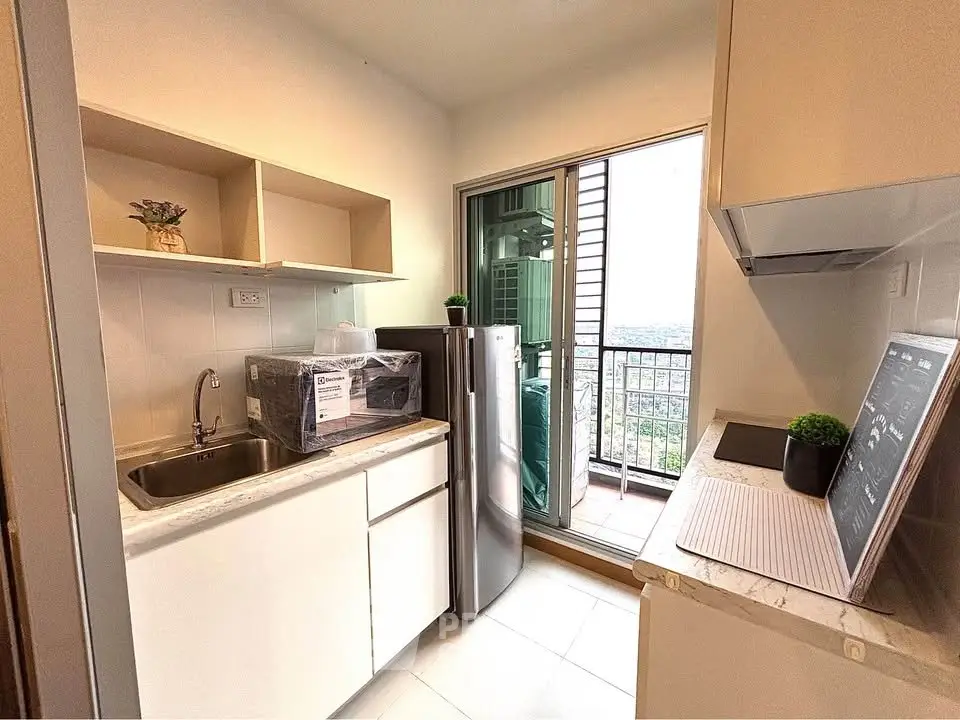 Modern kitchen with balcony view, featuring sleek appliances and open shelving, perfect for urban living.