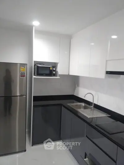 Modern kitchen with sleek cabinets and stainless steel appliances in a contemporary apartment.