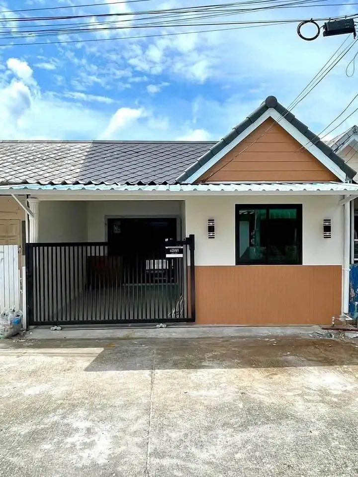 Charming single-story home with modern facade and gated entrance, perfect for cozy living.