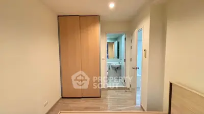 Modern bedroom with ensuite bathroom and wooden wardrobe in a cozy apartment.