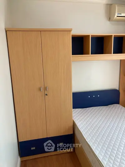 Modern bedroom with wooden wardrobe and comfortable mattress, perfect for a cozy living space.