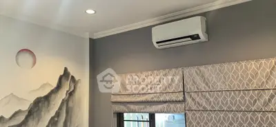 Modern living room with air conditioning and stylish wall art, featuring elegant window treatments.