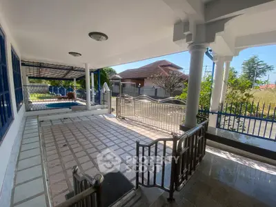 Spacious outdoor patio with elegant railing and tiled flooring, perfect for relaxation and gatherings.