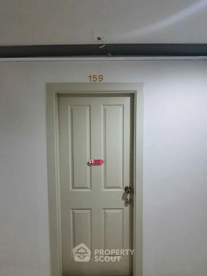 Apartment door with number 159 in a well-lit hallway, showcasing secure entry.