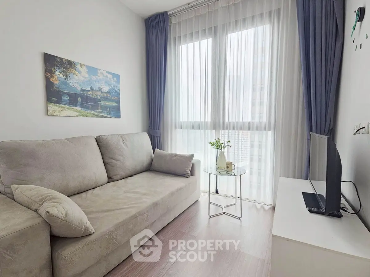Modern living room with cozy sofa, large window, and stylish decor in a bright apartment.
