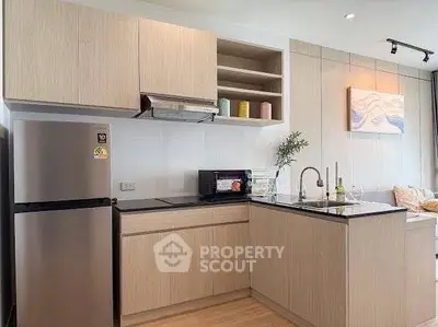 Modern kitchen with sleek cabinetry and stainless steel appliances in a stylish apartment.