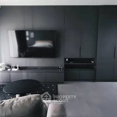 Modern living room with sleek black cabinetry and large flat-screen TV