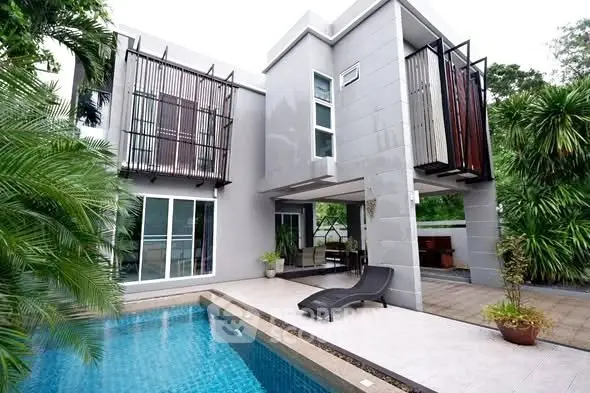 Modern luxury home with sleek design and private pool surrounded by lush greenery.
