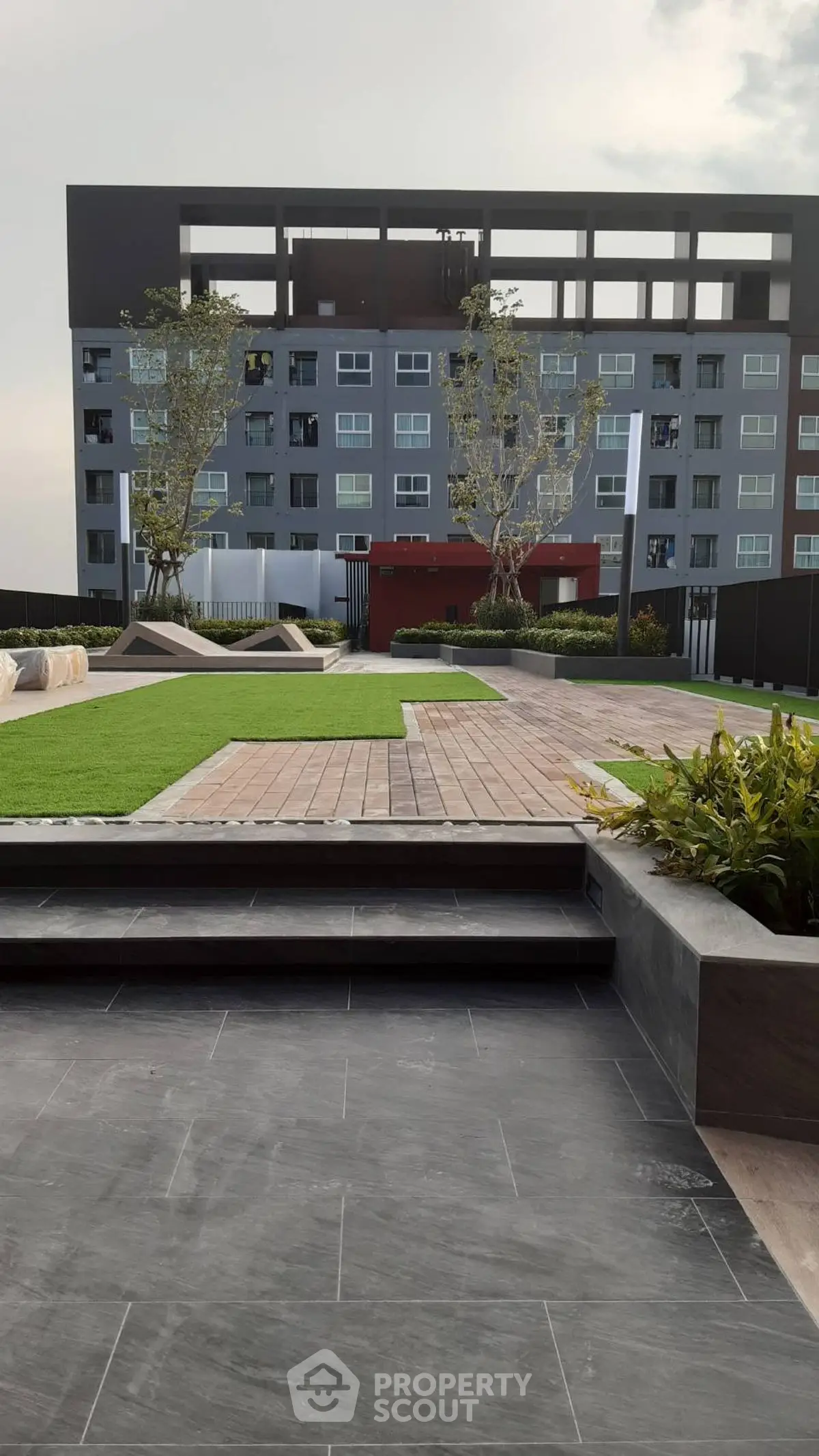Modern apartment building with landscaped garden and seating area