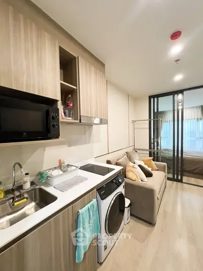 Modern studio apartment with compact kitchen and cozy living area