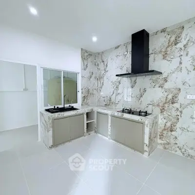 Modern kitchen with marble backsplash and gas stove in sleek open layout