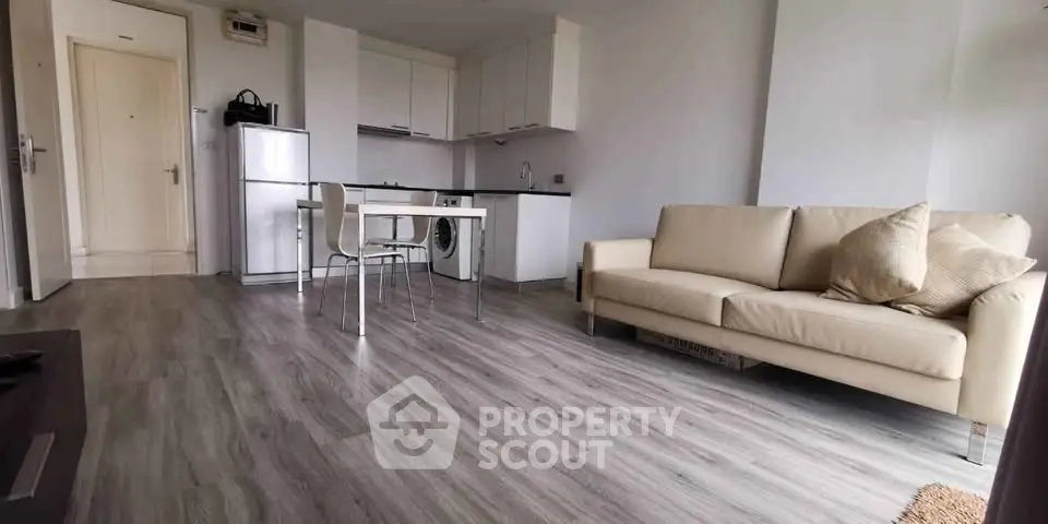 Modern open-plan living room with sleek kitchen and cozy seating area.