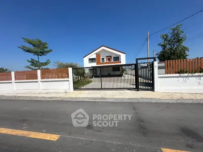 Modern two-story house with gated entrance and spacious driveway, perfect for family living.
