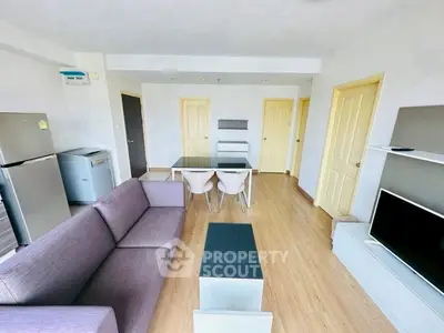 Modern living room with sleek furniture and open layout, featuring a dining area and stylish decor.