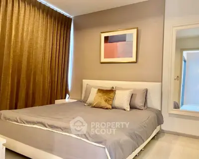 Elegant bedroom with modern decor and cozy ambiance, featuring a large bed and stylish artwork.