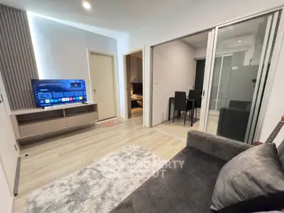 Modern living room with sleek design and sliding glass doors leading to a dining area.