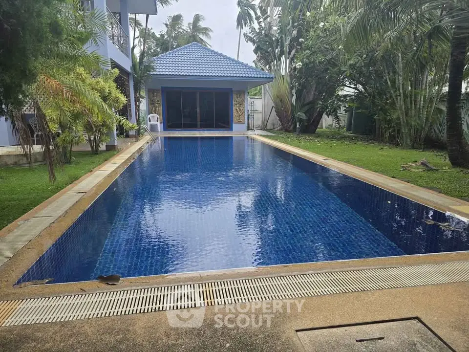 Stunning private pool with lush garden and modern pool house, perfect for relaxation and entertainment.