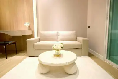 Modern living room with beige sofa, stylish coffee table, and elegant decor in a cozy apartment.