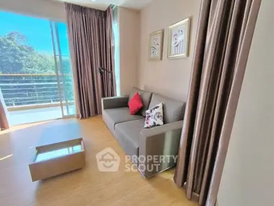 Bright living room with modern sofa and large balcony offering stunning views.