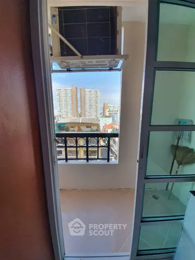 Cozy balcony view with air conditioning unit and cityscape in the background.