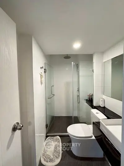 Modern bathroom with glass shower and sleek fixtures.