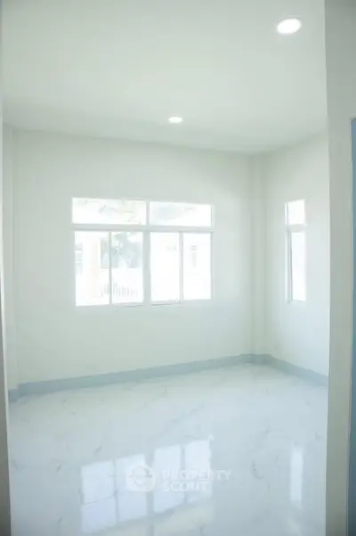 Bright and spacious empty room with large windows and marble flooring