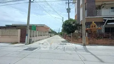 Charming residential street view with modern houses and lush greenery.