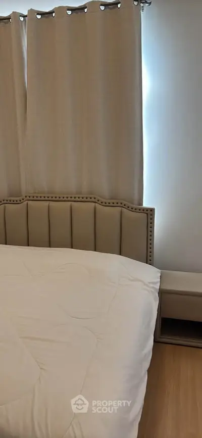 Cozy bedroom with elegant bed and neutral curtains, perfect for relaxation.