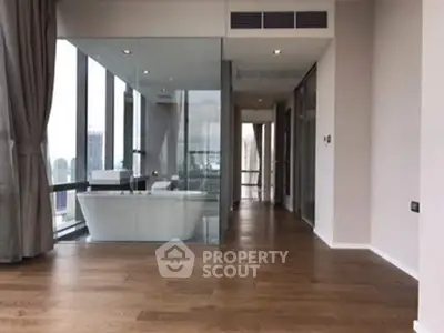 Luxurious modern apartment with glass-enclosed bathtub and panoramic city views.