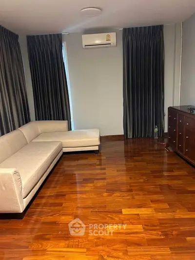 Spacious living room with elegant wooden flooring and modern furniture