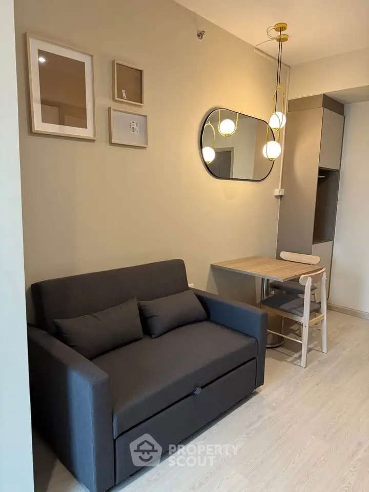 Modern living room with stylish sofa, wall art, and chic lighting in a cozy apartment.