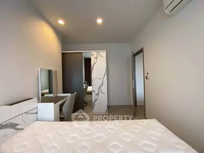Modern bedroom with sleek design and air conditioning, featuring a stylish desk and comfortable bed.