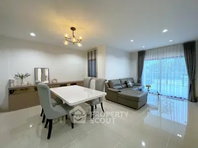 Spacious modern living room with elegant dining area and large windows for natural light.