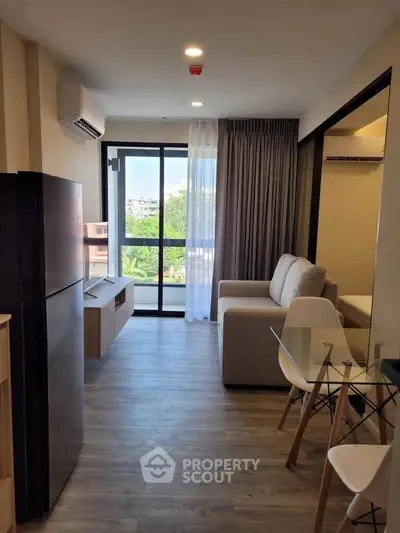 Modern living room with balcony view, featuring sleek furniture and natural light.