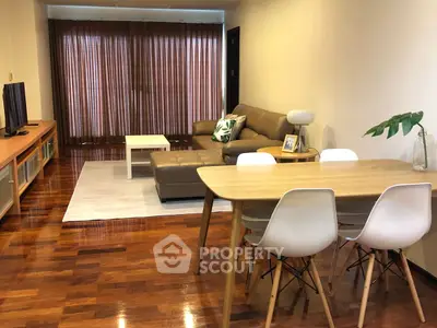 Modern living room with wooden floors, stylish furniture, and natural light.
