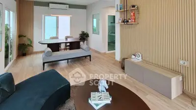 Modern living room with stylish decor and natural light, featuring wooden flooring and contemporary furniture.