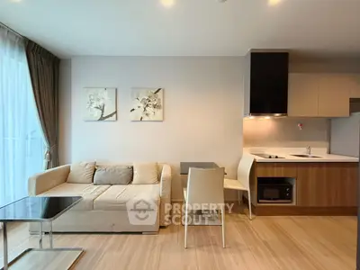 Modern living room with open kitchen, stylish decor, and natural light