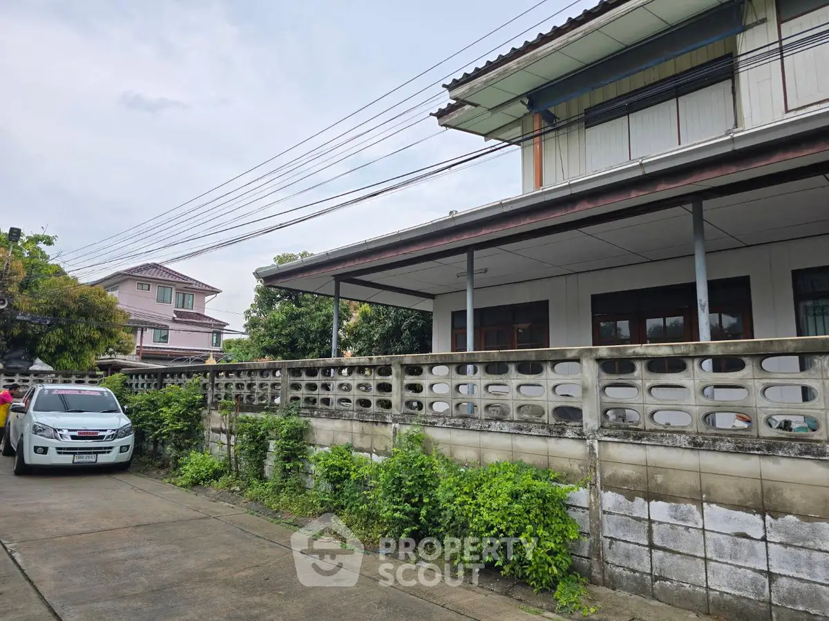 Charming suburban house with spacious driveway and lush greenery, perfect for family living.