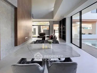 Luxurious modern living room with open layout and pool view, featuring elegant dining area and sleek design.