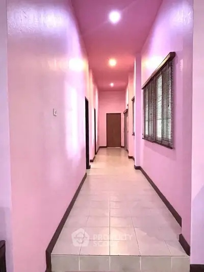 Spacious pink hallway with tiled flooring and modern lighting.